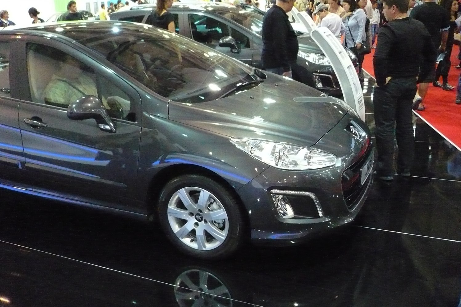 Front side view showing headlights and alloy wheels of a hatchback.