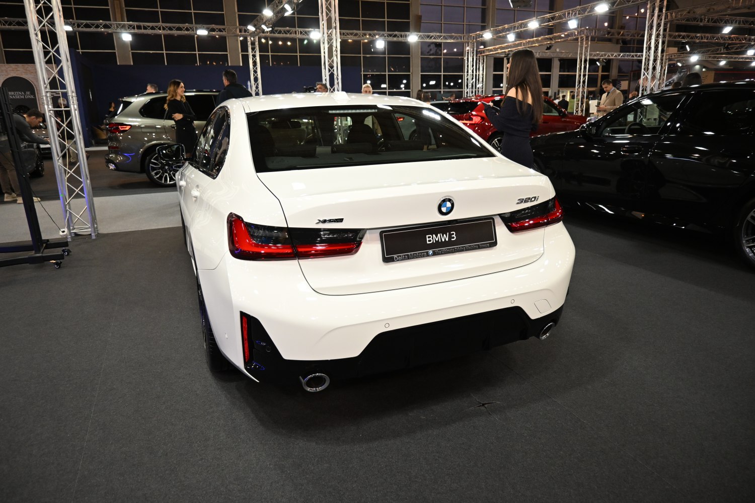 Rear view of a white sedan with distinctive tail lights and dual exhaust outlets