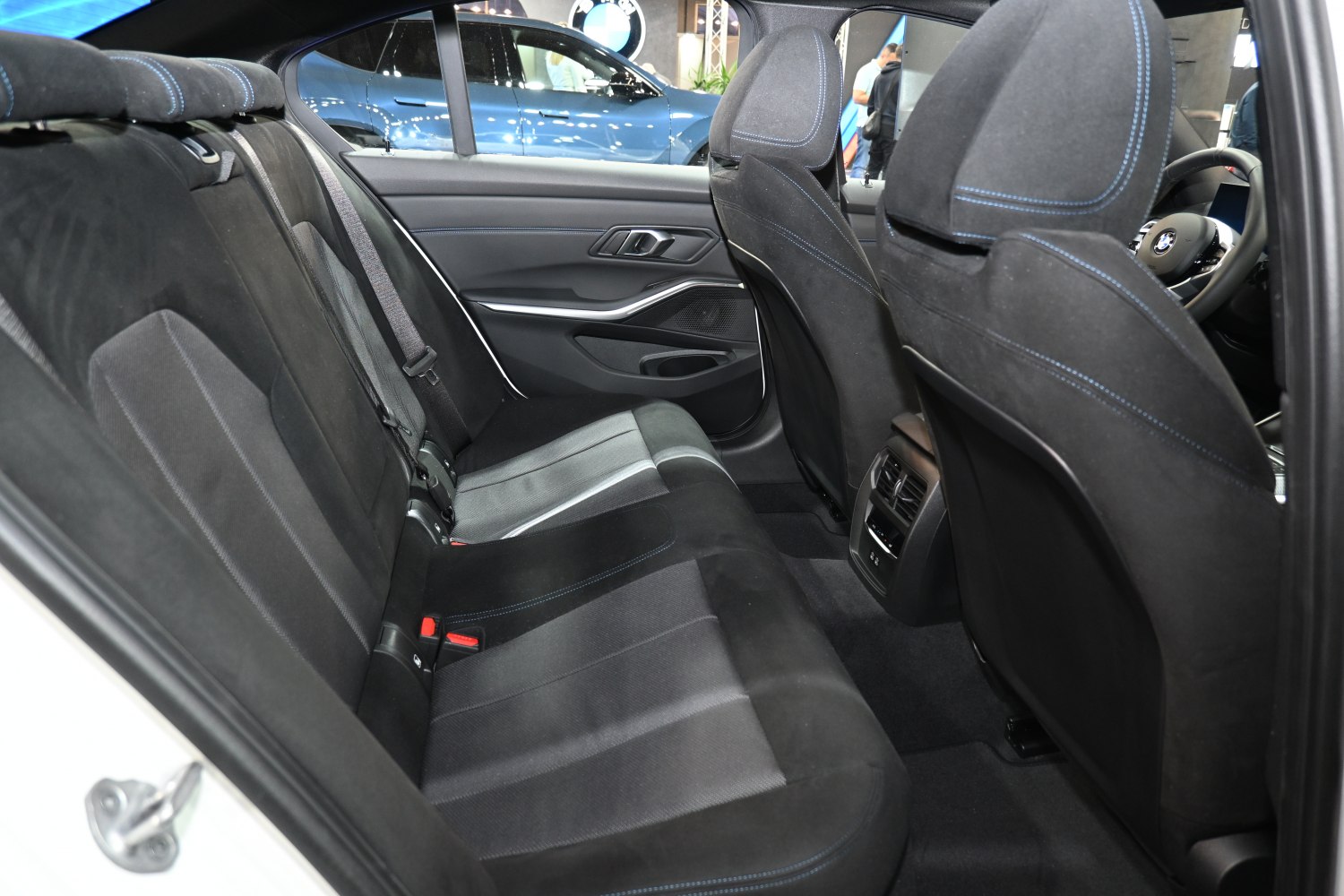 Rear seat interior with upholstery and blue stitching, rear air vents