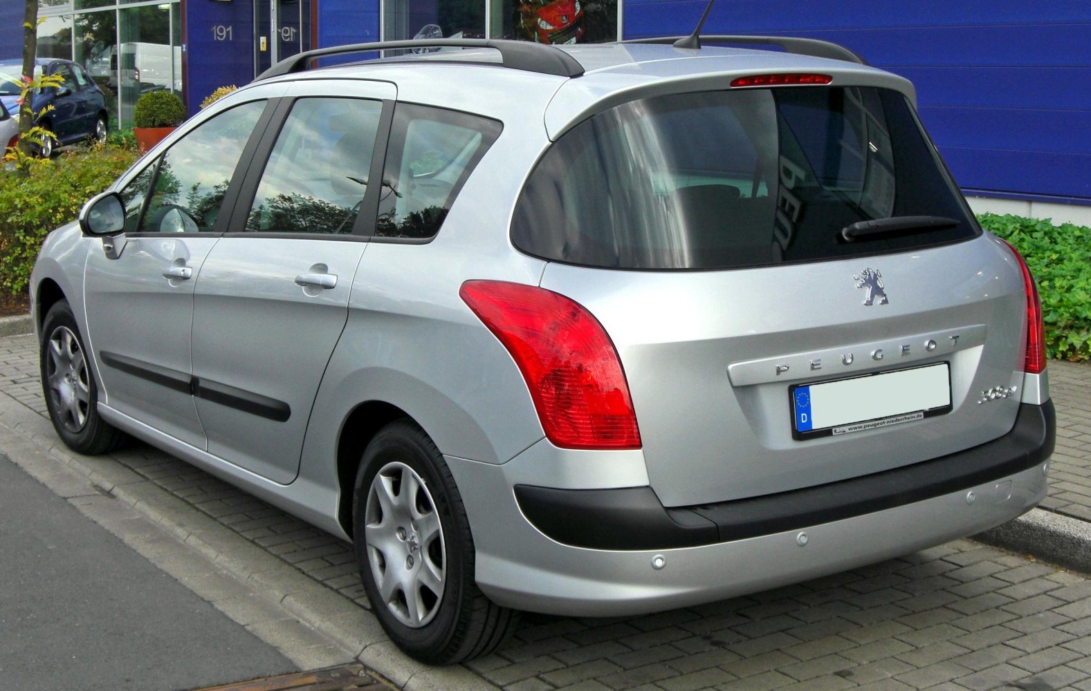 Rear and side view of a silver compact estate with distinct tail lights.