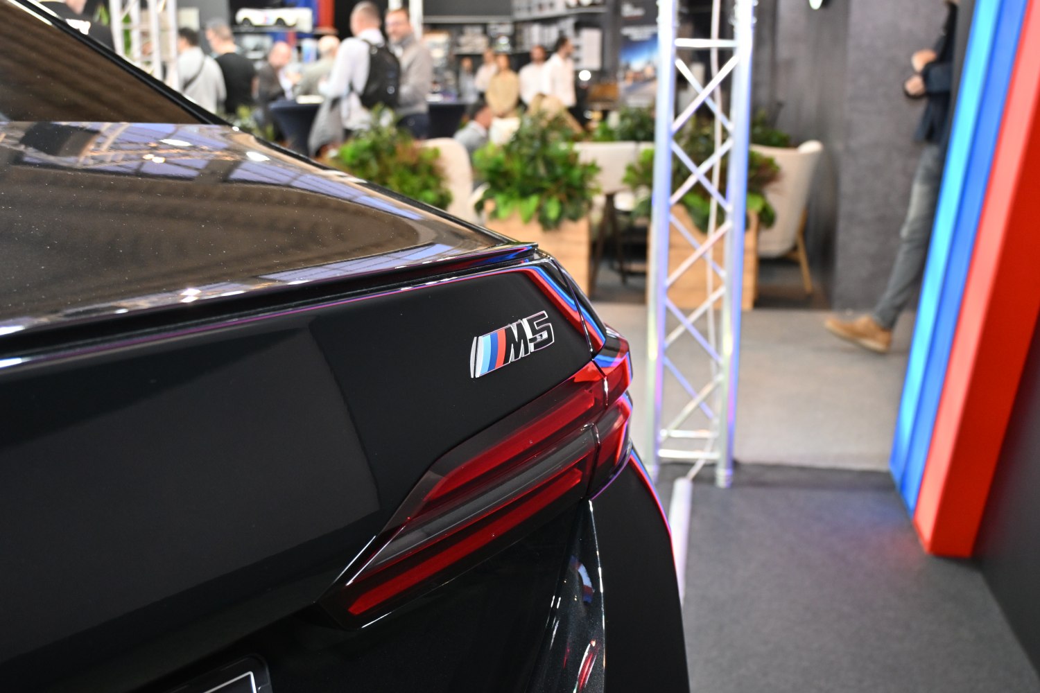 Rear badge and tail light detail with M5 emblem on black paint