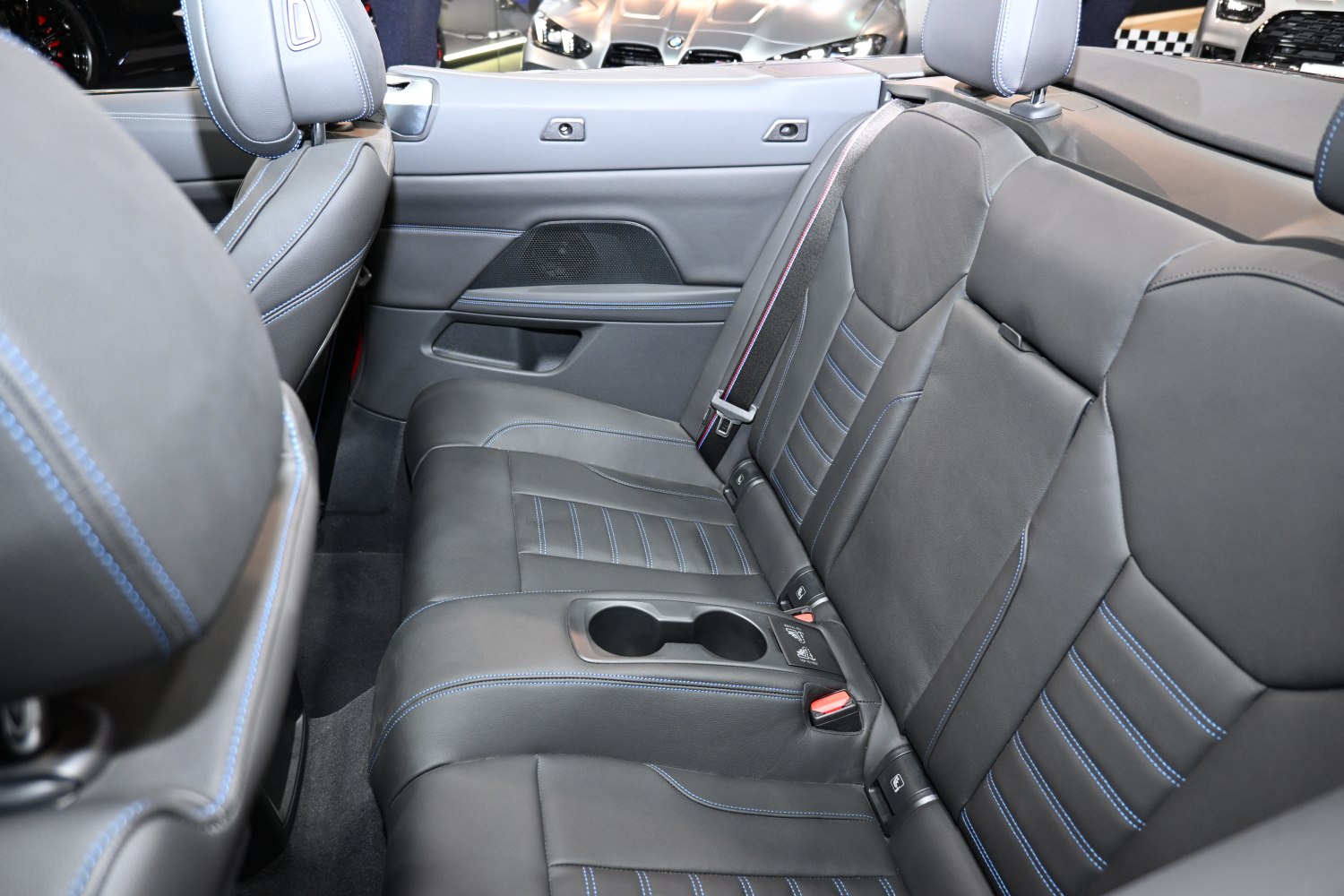 Black leather rear seats with blue stitching and cup holders