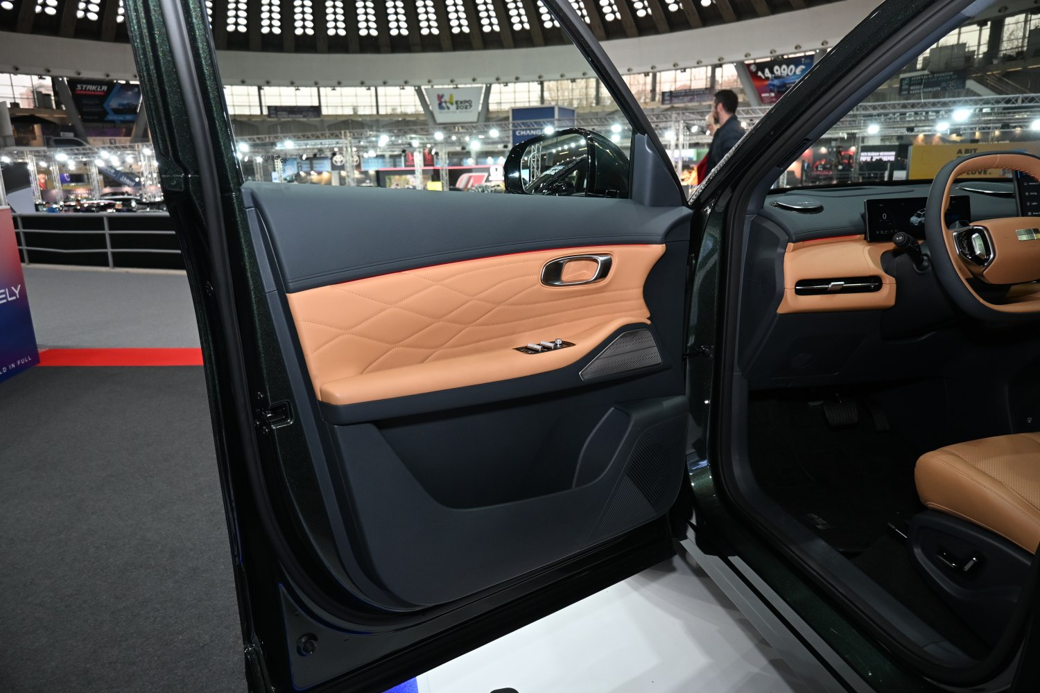 Leather-trimmed interior door panel with driver controls and speaker