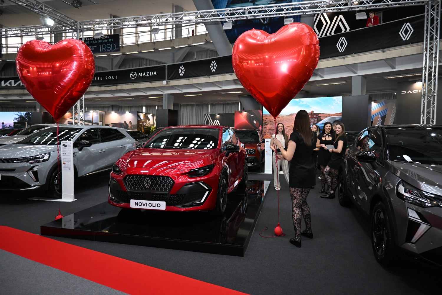 Front view of red car with two large red heart-shaped balloons