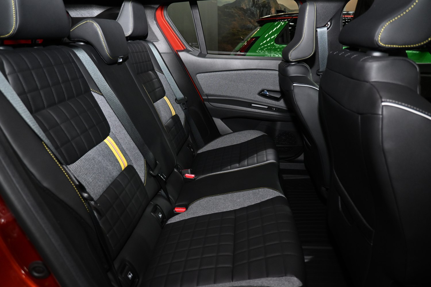 Rear seats with quilted black fabric and yellow stitching in modern interior.
