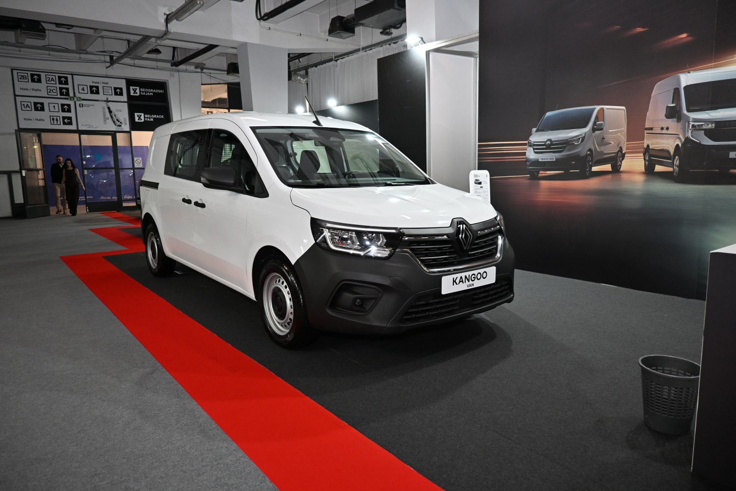 White van with black grille and steel wheels in exhibition space