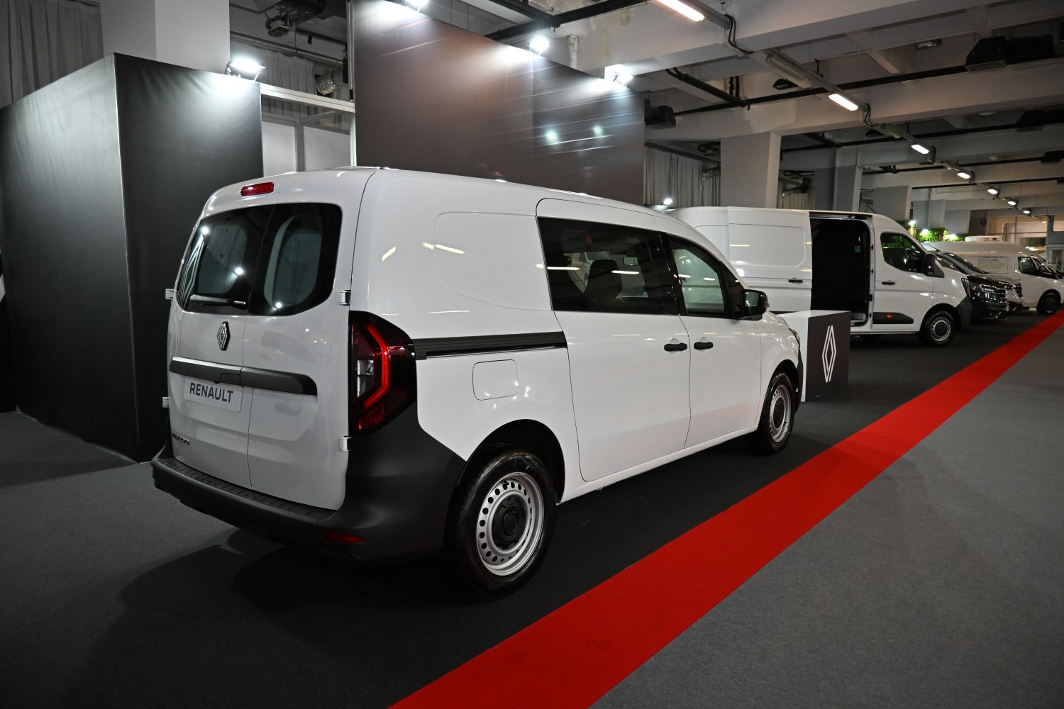 Rear side view of a white cargo van with black trim and sliding door