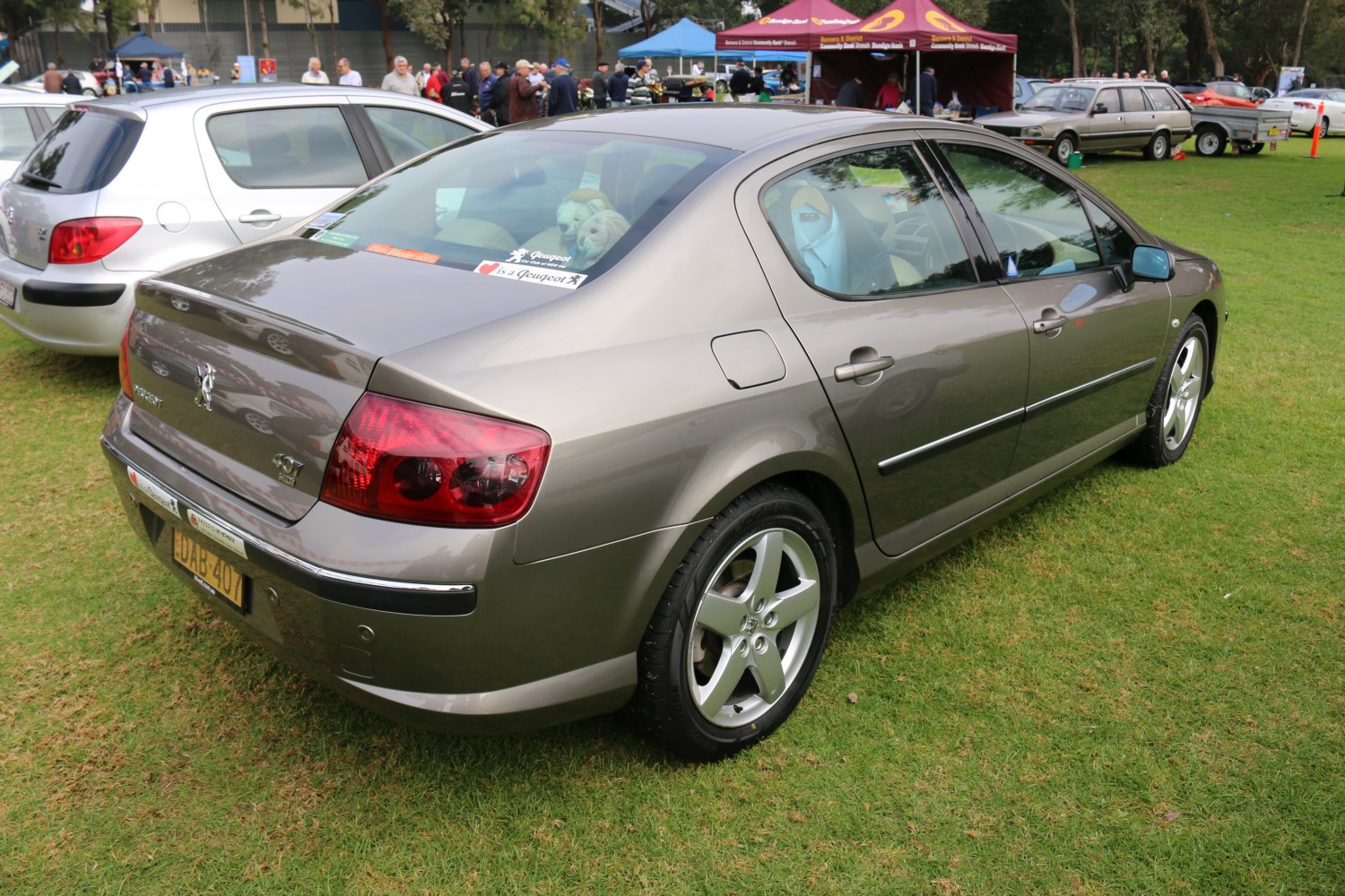 Rear and side profile of a sedan with alloy wheels and red tail lights