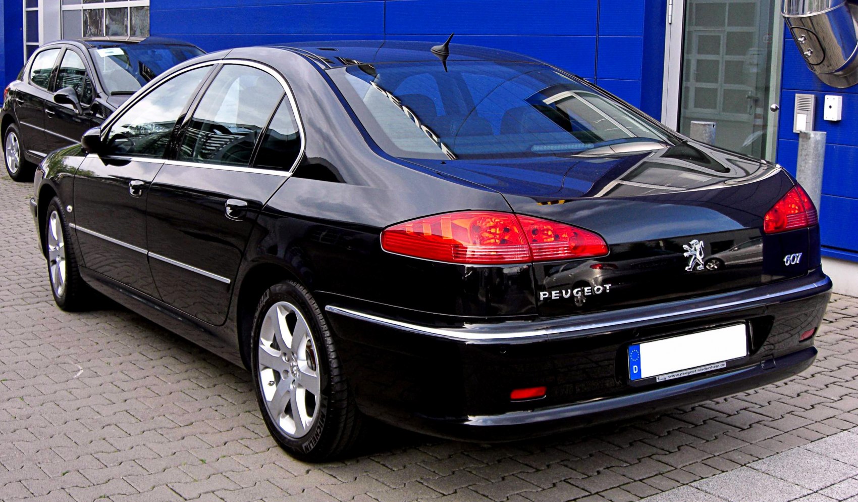 Rear view of a black luxury sedan with distinctive taillights and chrome trim