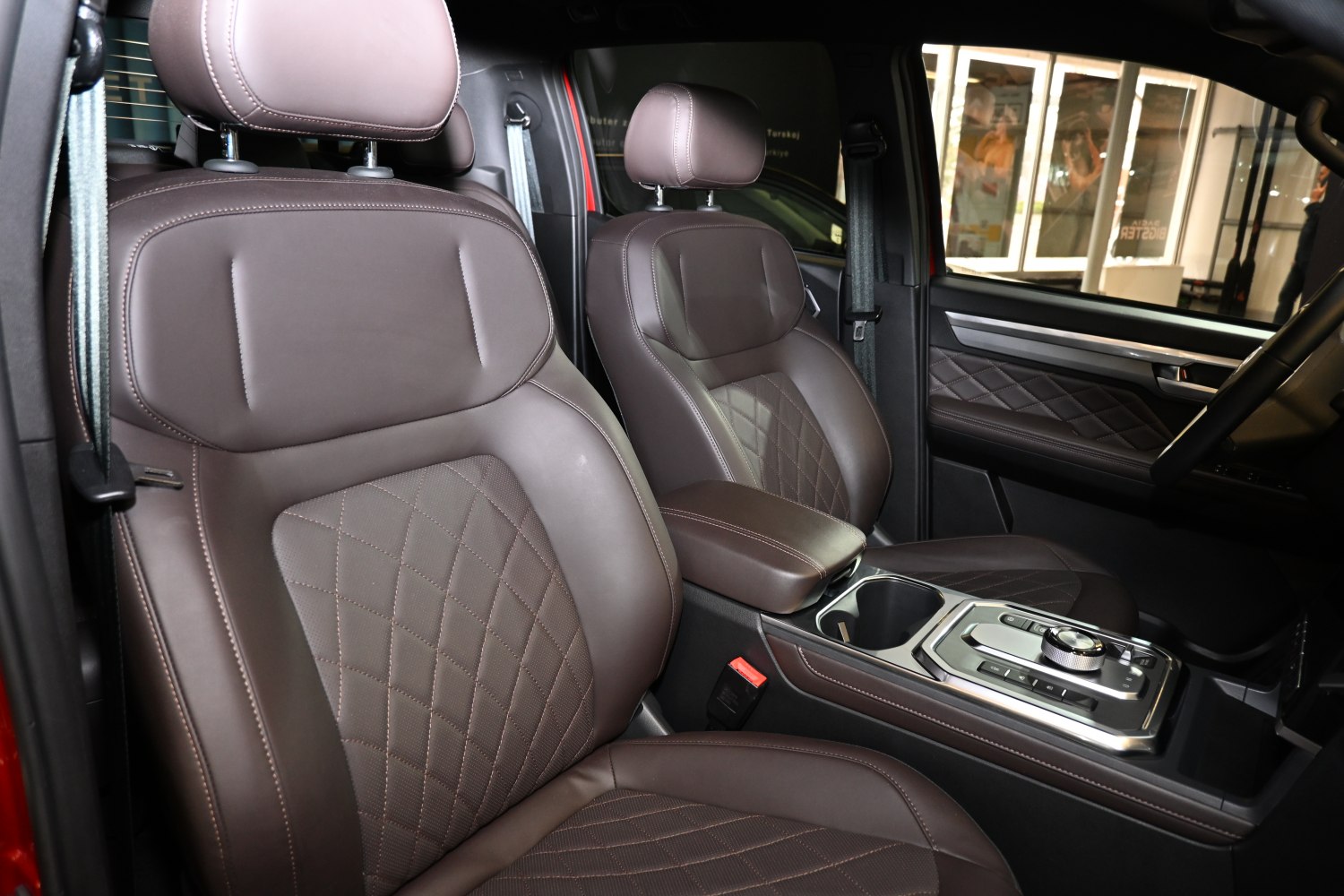 Brown leather seats with quilted pattern and modern center console.