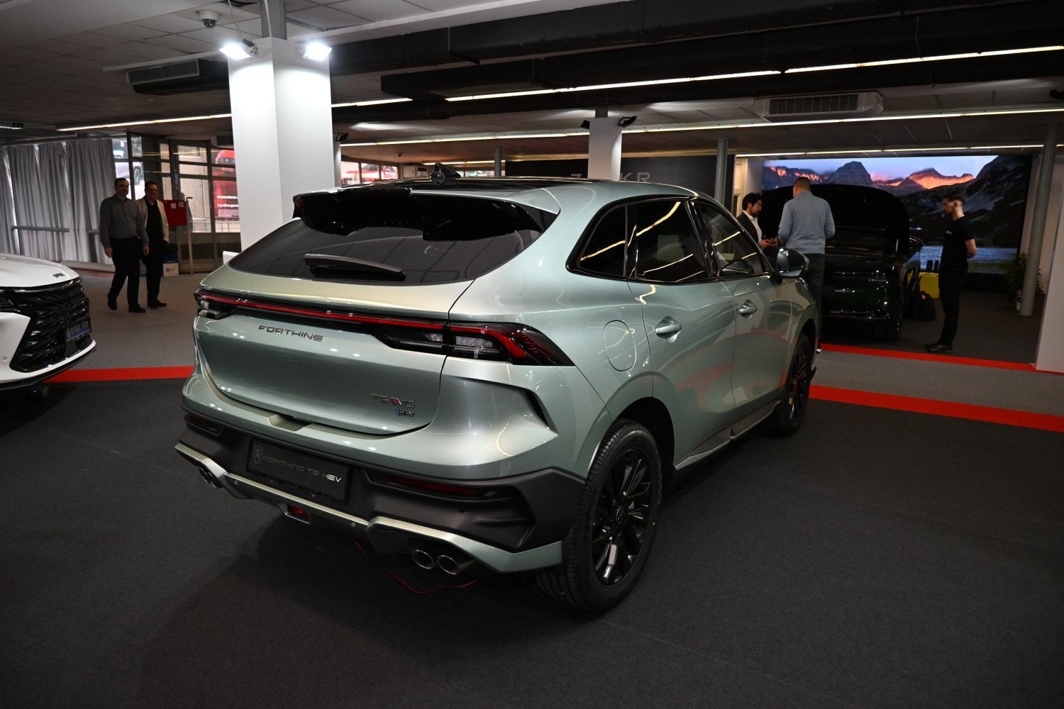 Modern SUV rear with continuous LED taillights and quad exhaust tips.