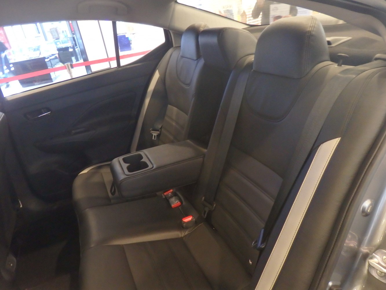 Rear black leather seats with center armrest and cup holders.