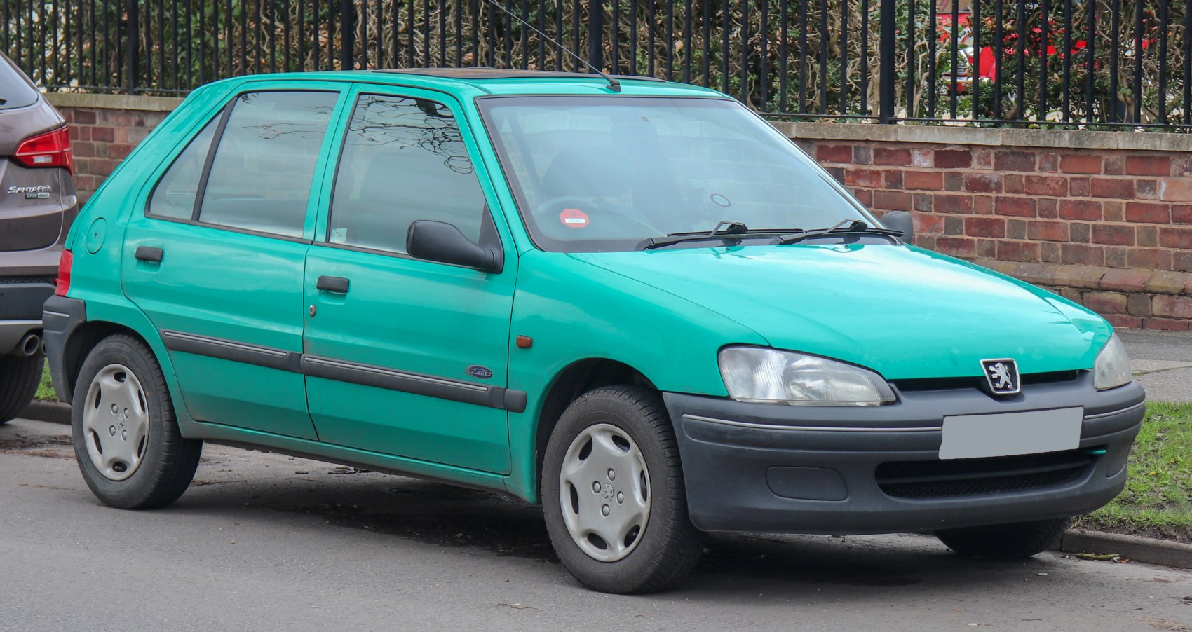 Turquoise compact hatchback with black plastic bumpers and wheel covers