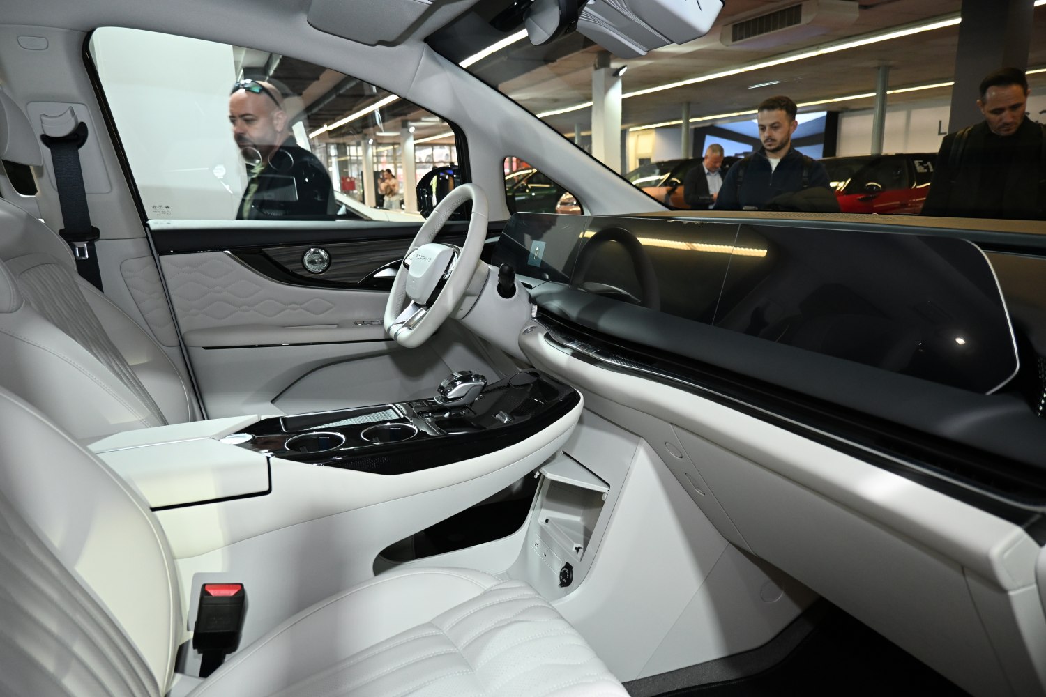 Modern digital dashboard and white leather steering wheel in car interior