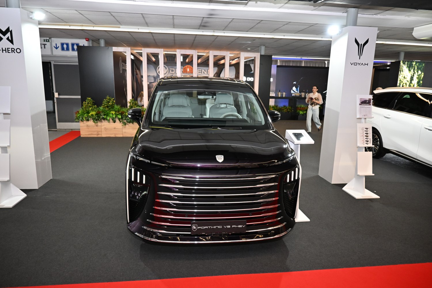 Front view with wide chrome grille and vertical LED headlights