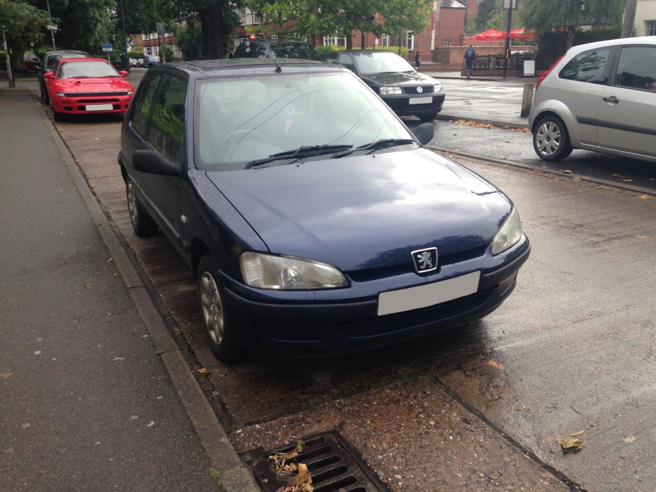 Compact dark blue hatchback with clear headlights and simple grille.