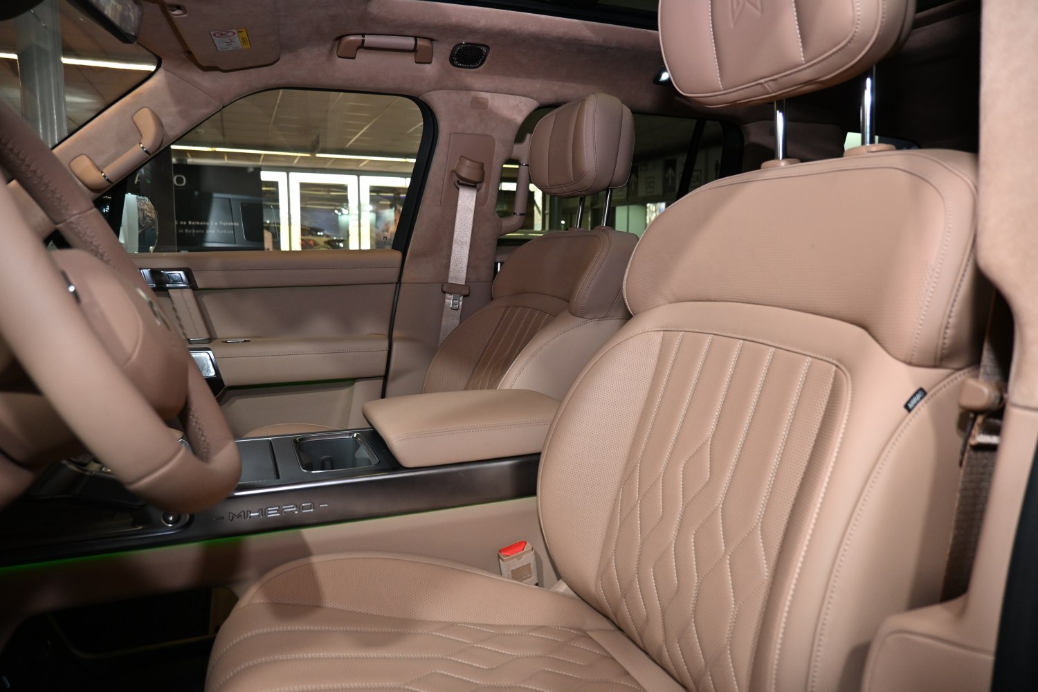 Beige leather front seats with detailed stitching and a modern center console.