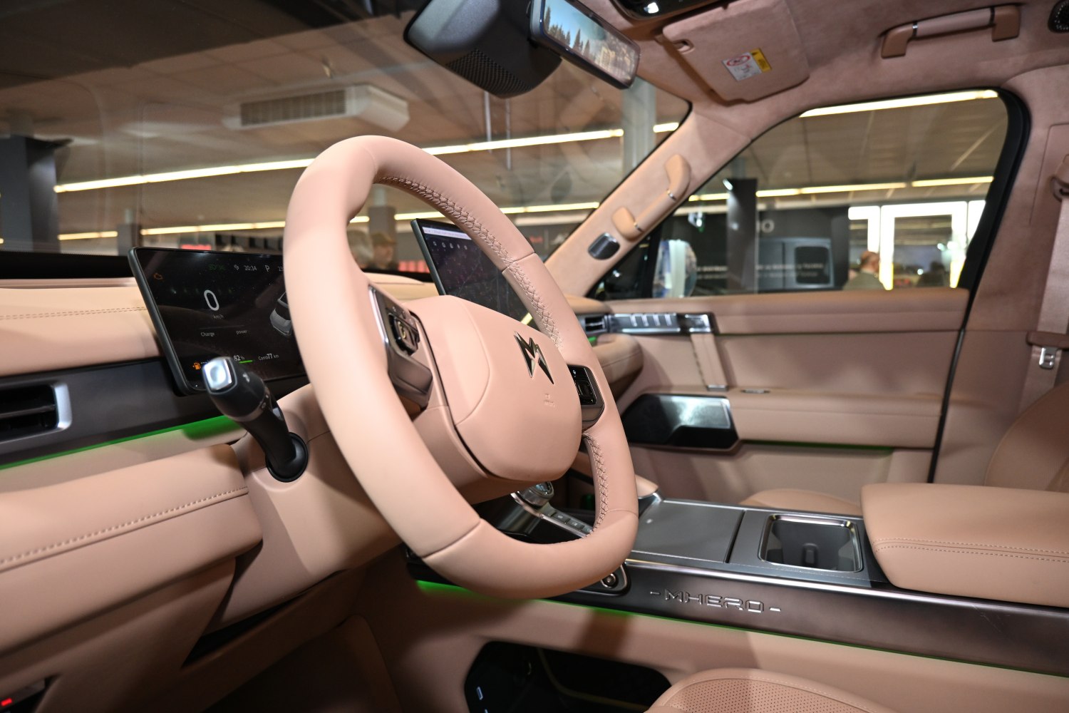Beige leather interior with digital dashboard and steering wheel.