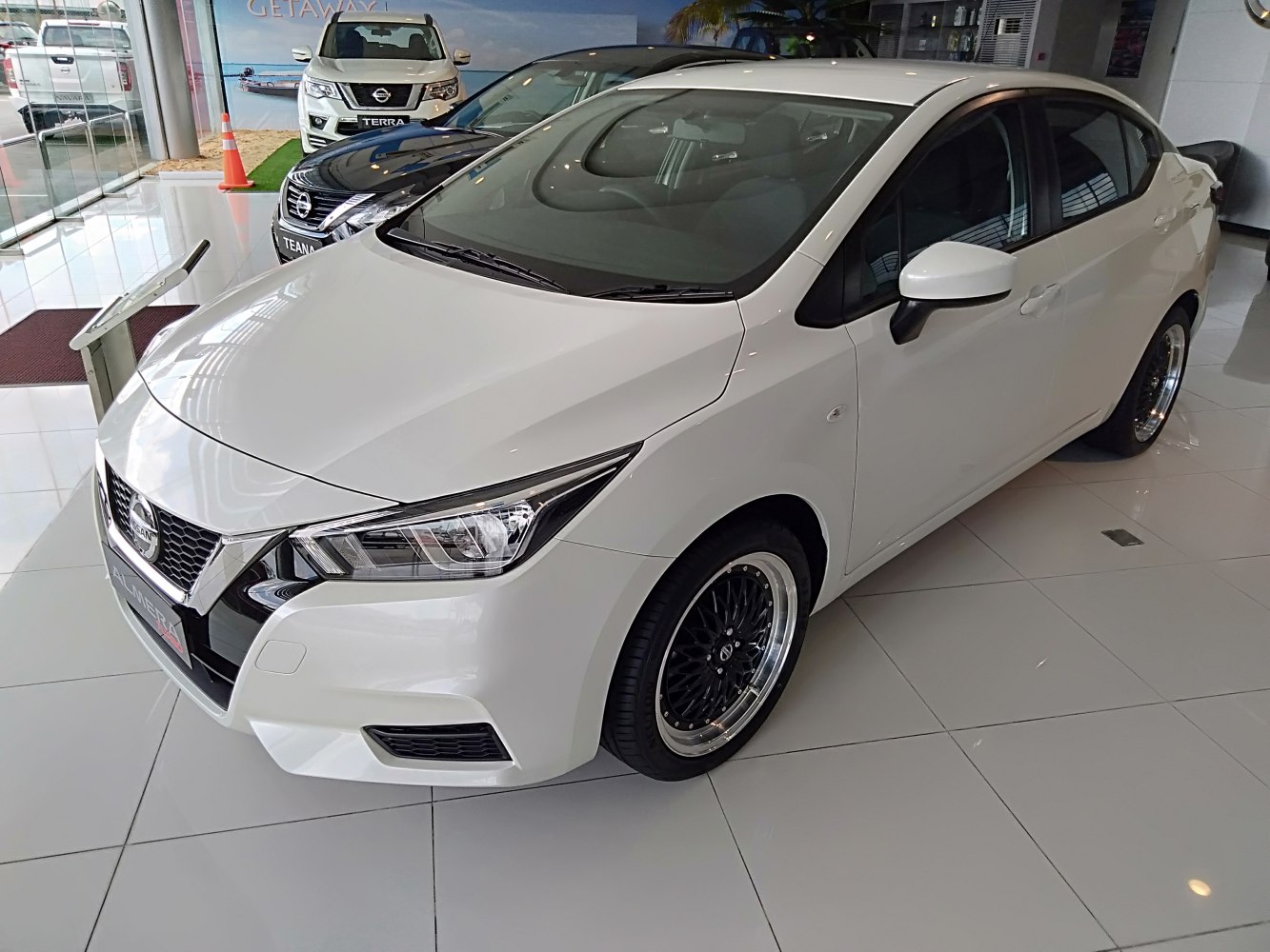 White sedan with sharp headlights and sporty black multi-spoke alloy wheels