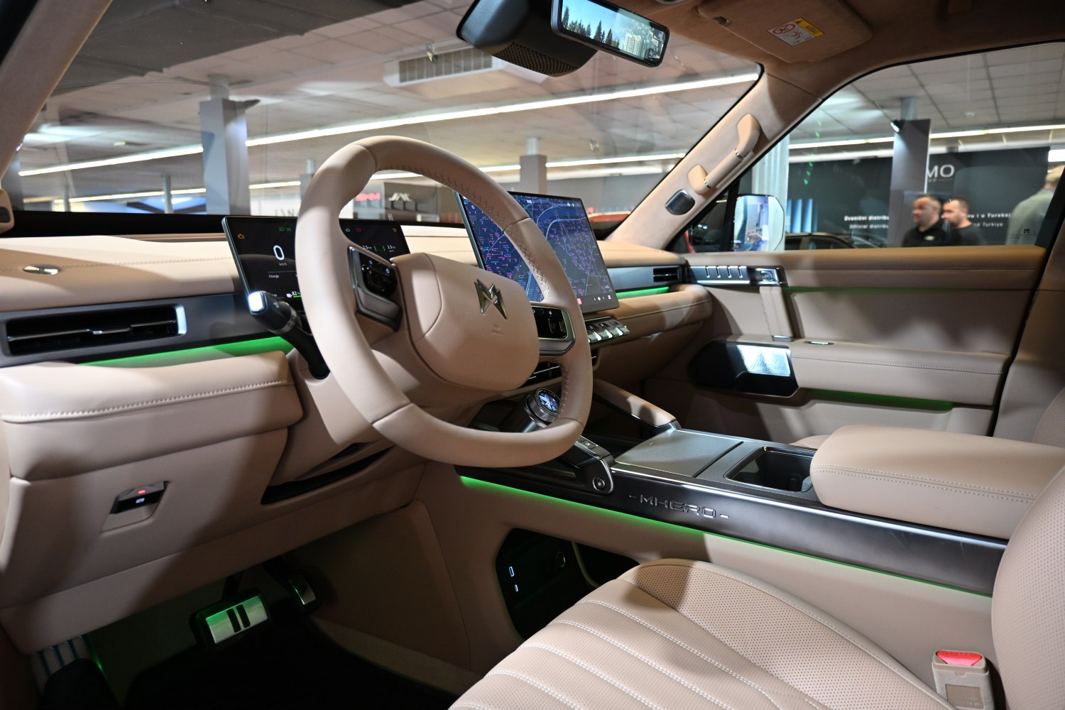 Modern beige car interior with digital displays and green ambient lighting