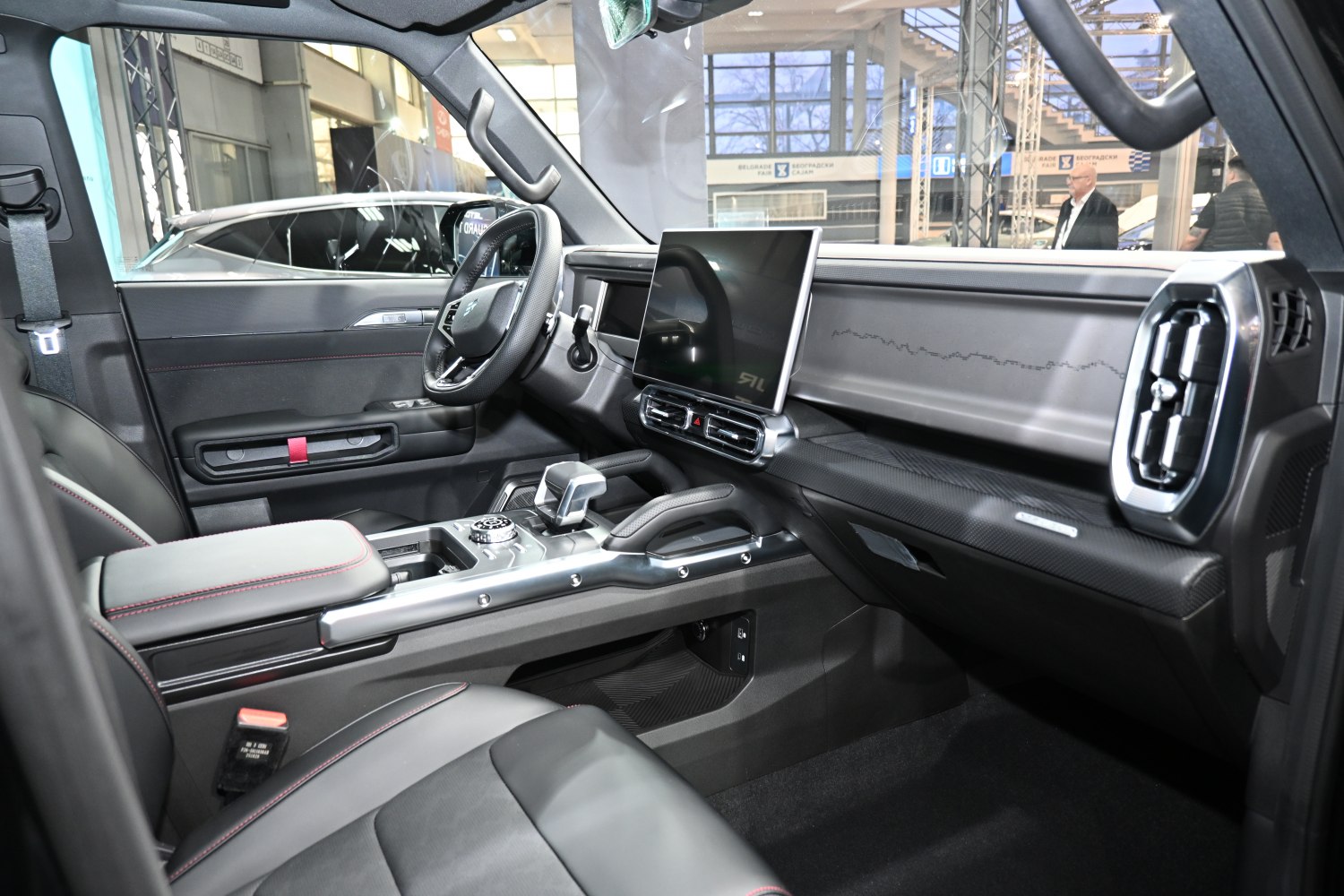 Modern car interior with large touchscreen and sleek dashboard.
