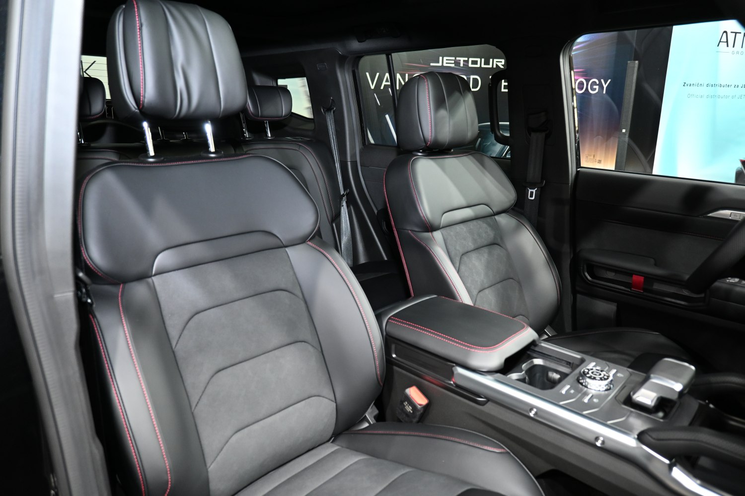 Luxury leather seats with red stitching and modern center console layout