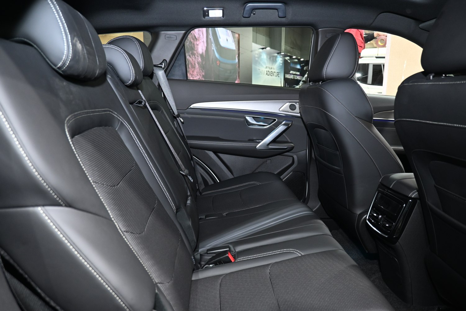 Spacious rear seat area with black leather upholstery and detailed stitching.