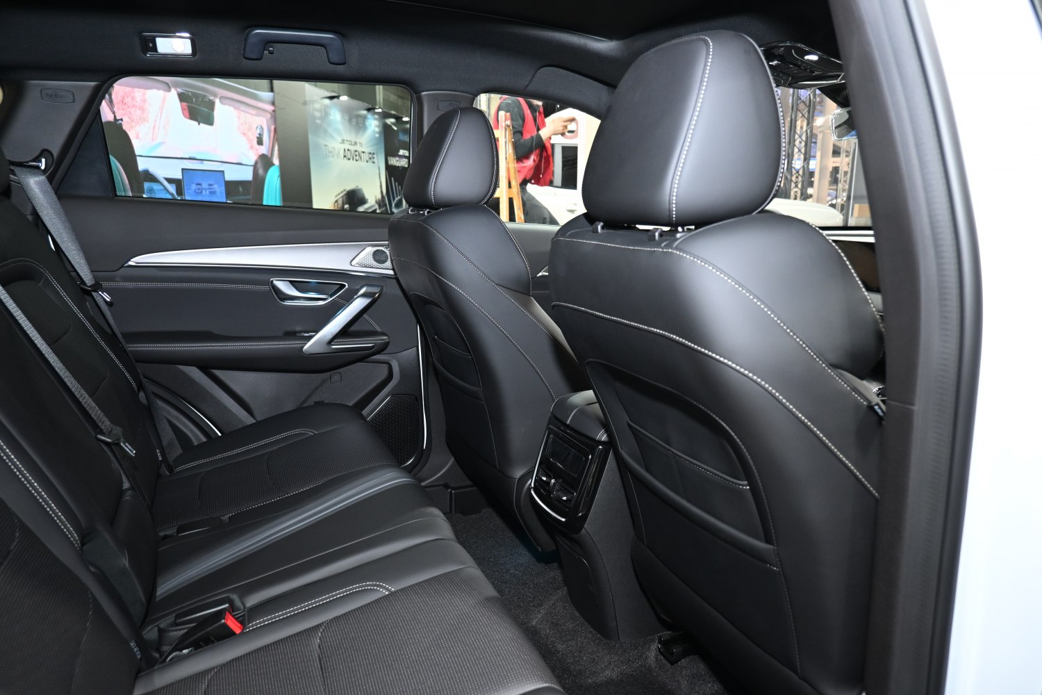 Rear seating and door panel with black leather upholstery and white stitching