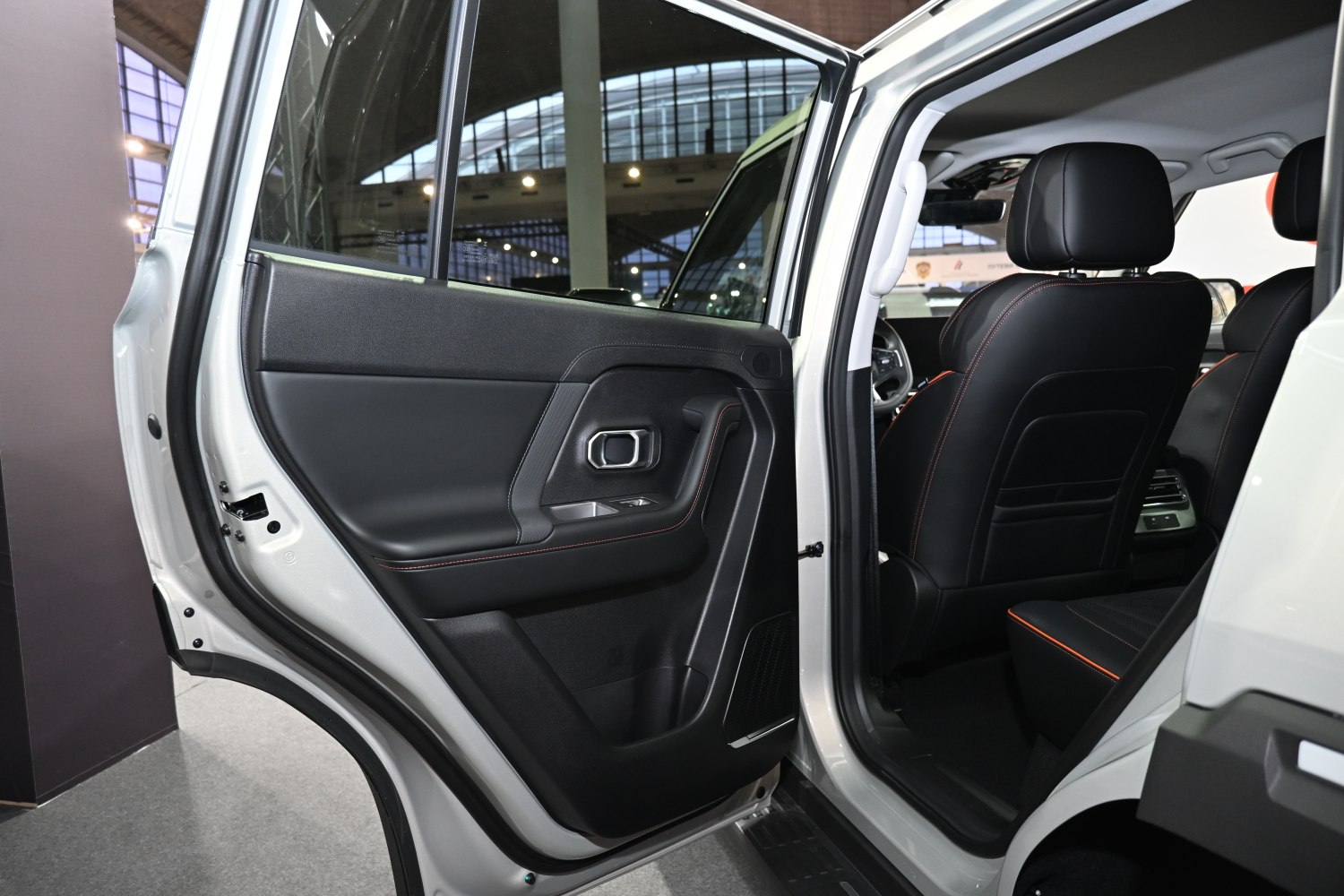 Rear door interior panel with black leather and orange stitching