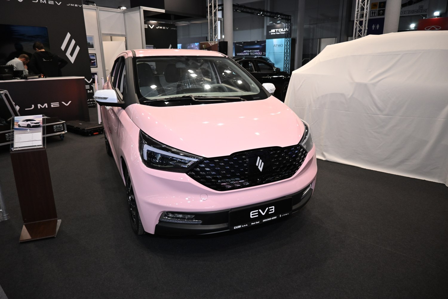 Compact electric hatchback front with sleek headlights and black grille