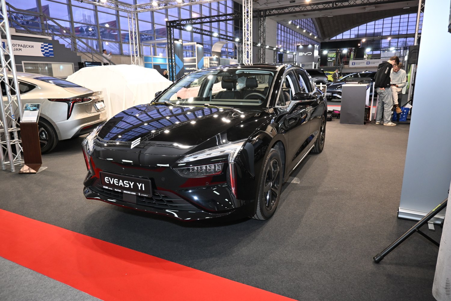 Black electric sedan front view with LED headlights and glossy finish