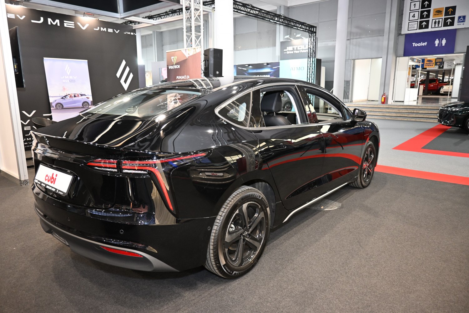 Rear view of sleek black electric sedan with LED taillights and aerodynamic styling