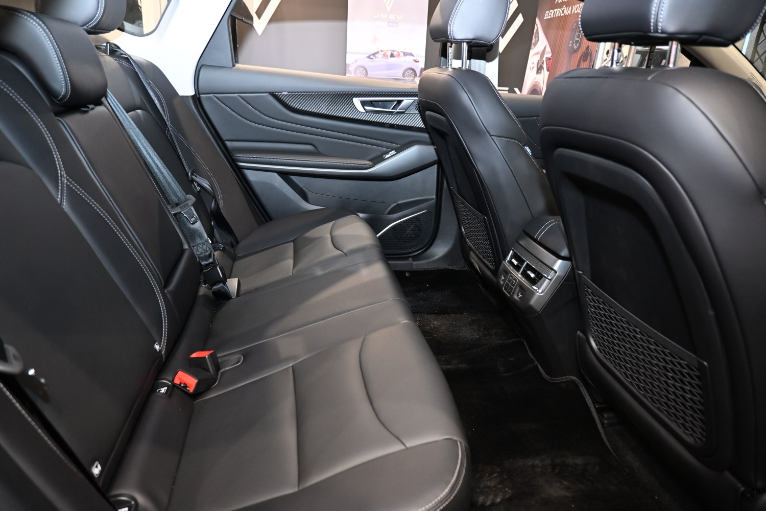 Premium black leather rear seats with white stitching and rear climate control panel