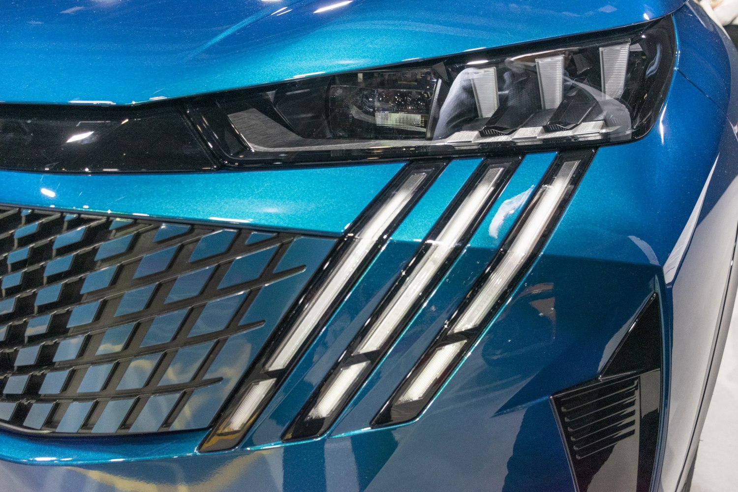 LED headlights with triple vertical light strips and a patterned front grille.