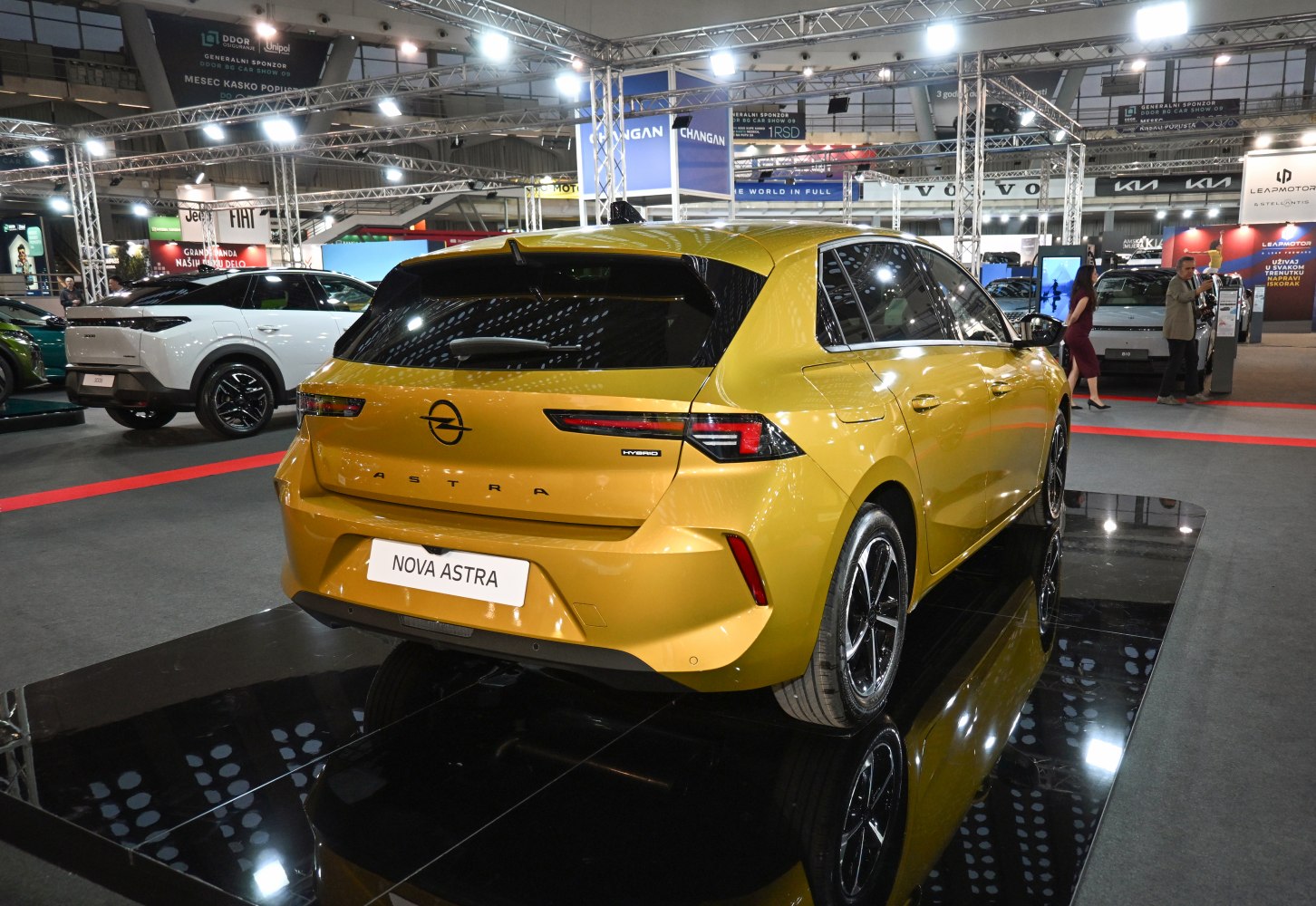 Rear view of yellow hatchback with hybrid badge and modern taillights