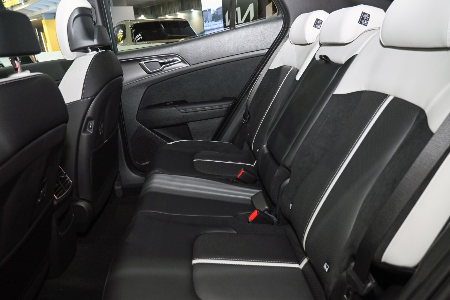 Stylish black and white rear seat interior with headrests and seat belts