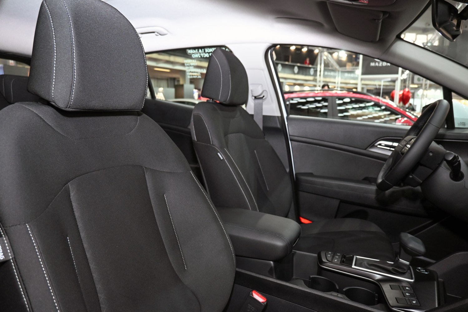 Black front seats with white stitching and modern gear shift console