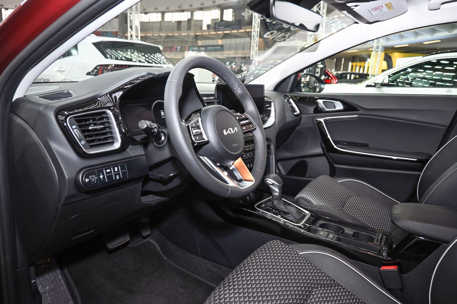 Modern steering wheel with controls and automatic gearshift in vehicle interior.