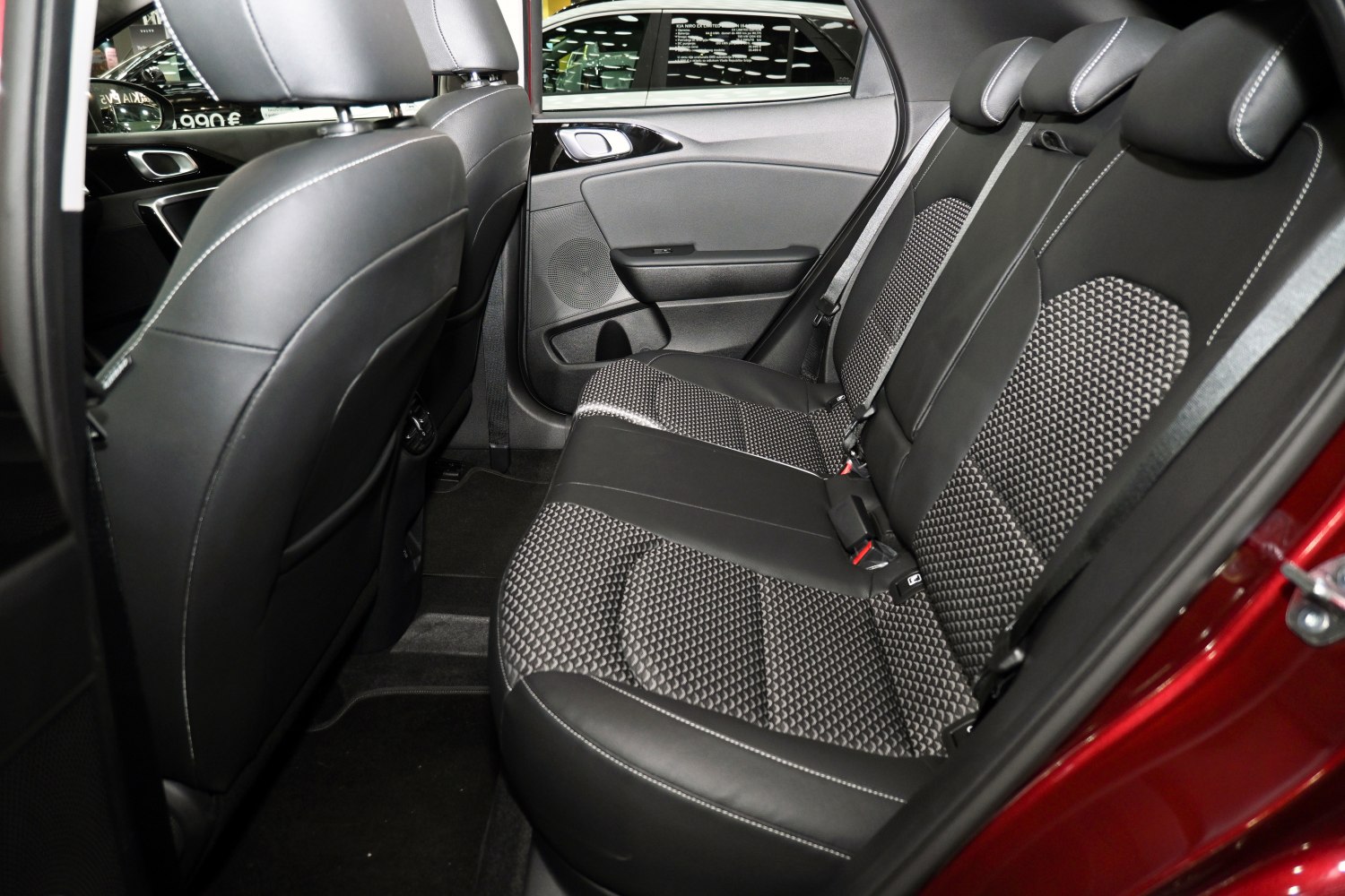 Rear seat interior with black leather and patterned fabric upholstery