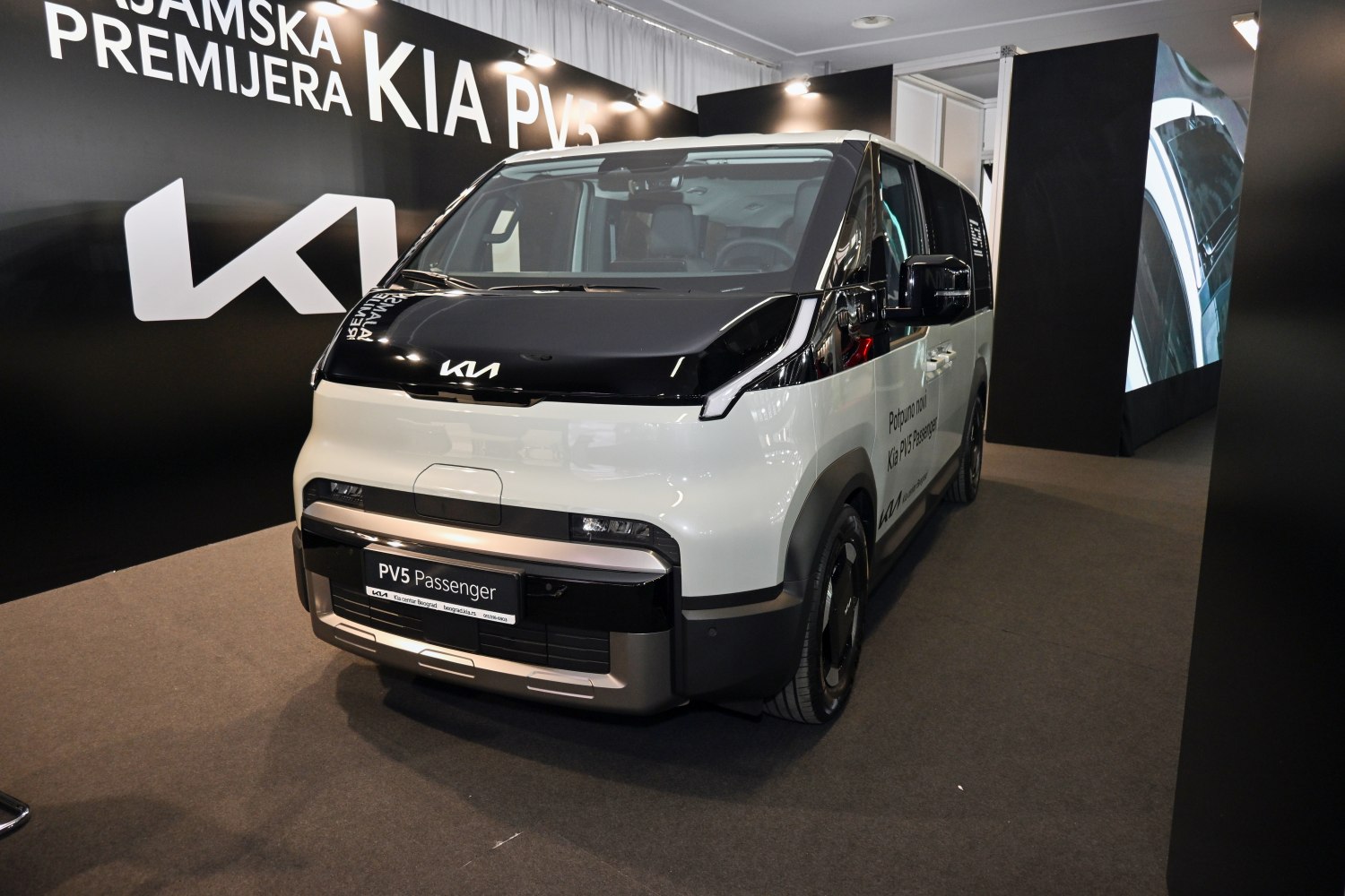 Boxy electric van with futuristic front design and black-white contrast.