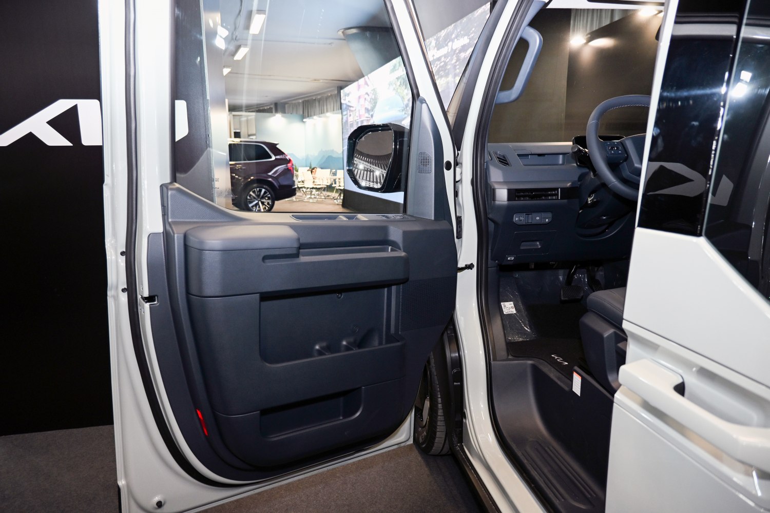 Interior door panel and driver's seat with steering wheel.