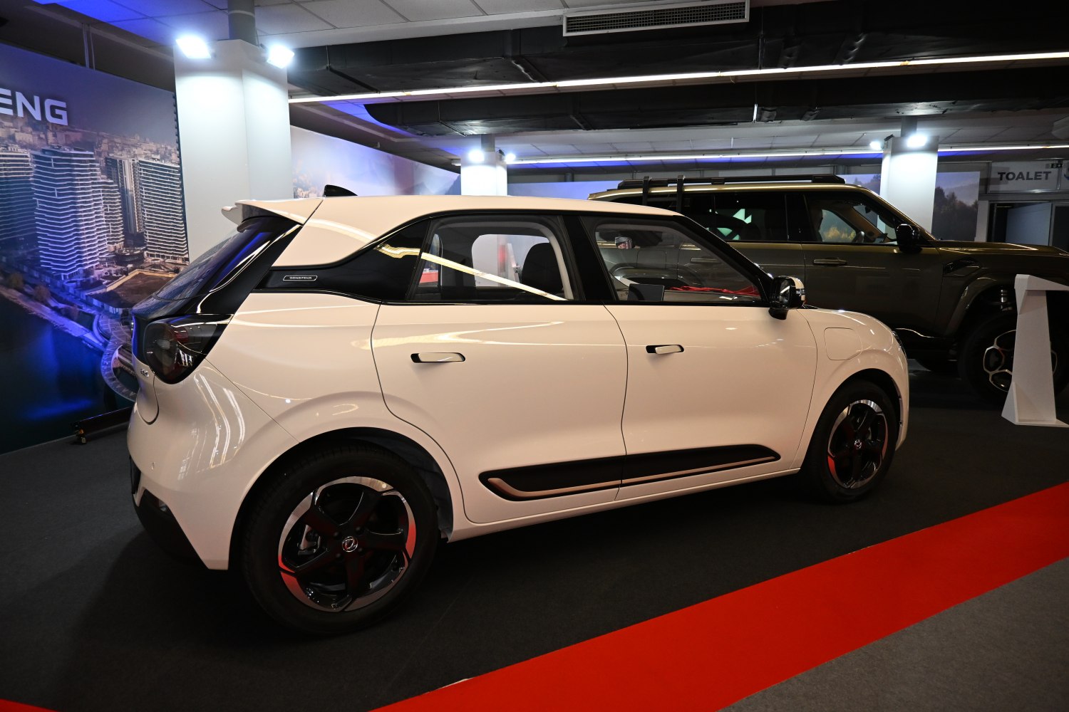 Compact hatchback side profile with black-accented design and modern wheels
