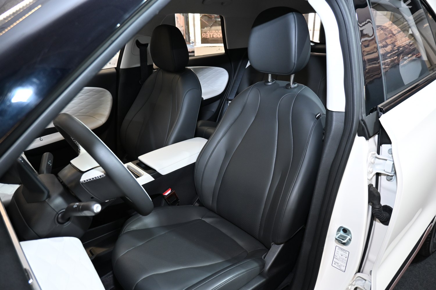 Modern black leather front seats with white quilted door accents