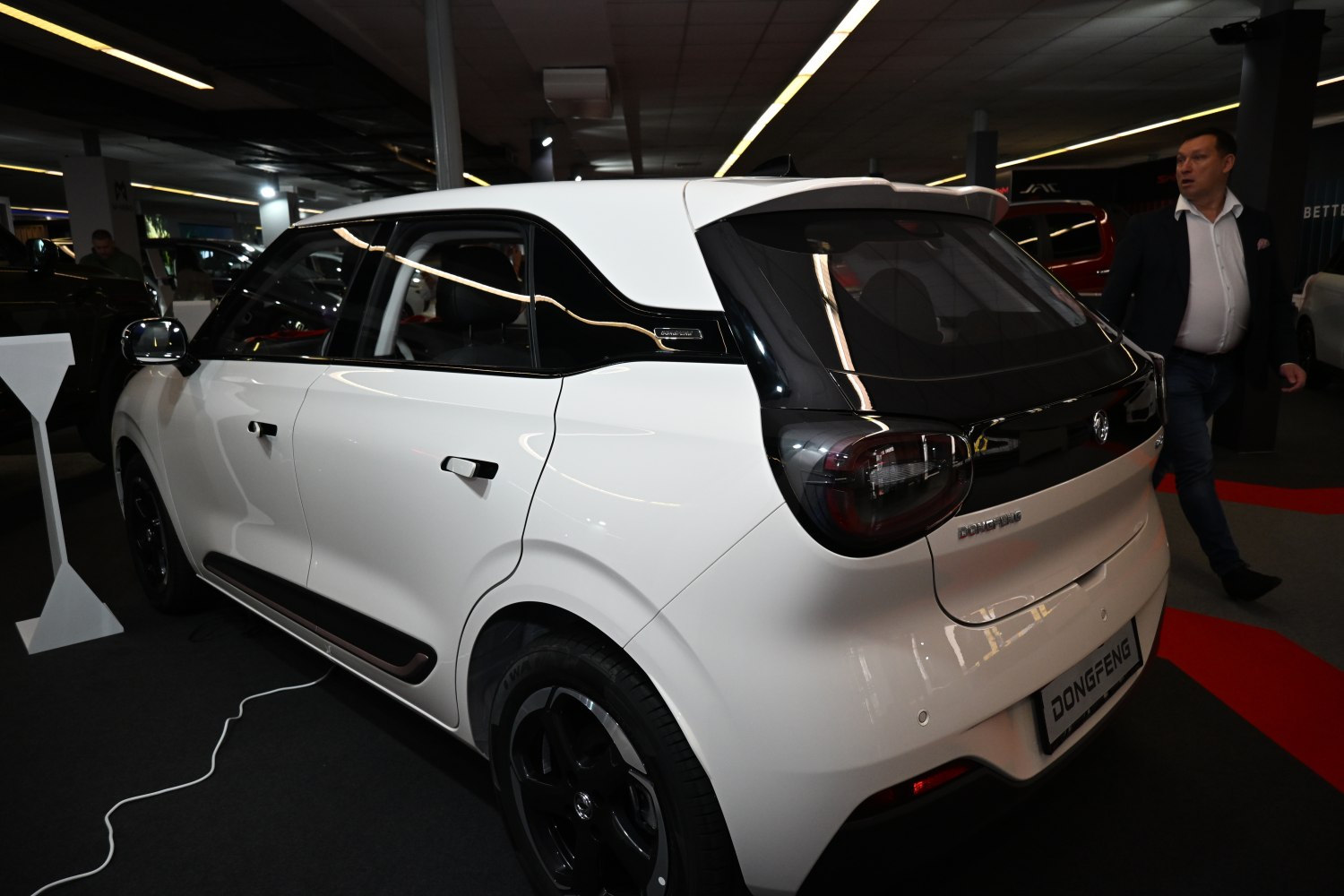 Rear side view of a sleek white hatchback with black window trim and modern tail lights