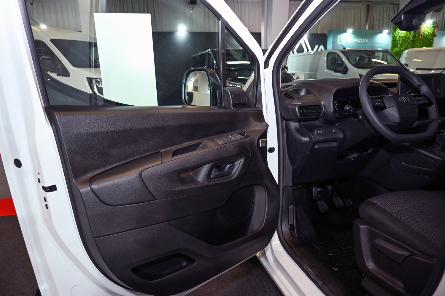 Interior driver door panel and dashboard with steering wheel and controls