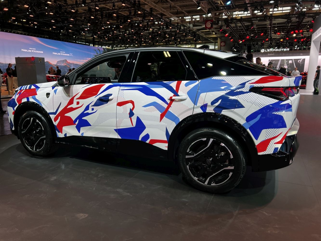 Side view of SUV with red, white, and blue camouflage wrap and black alloy wheels