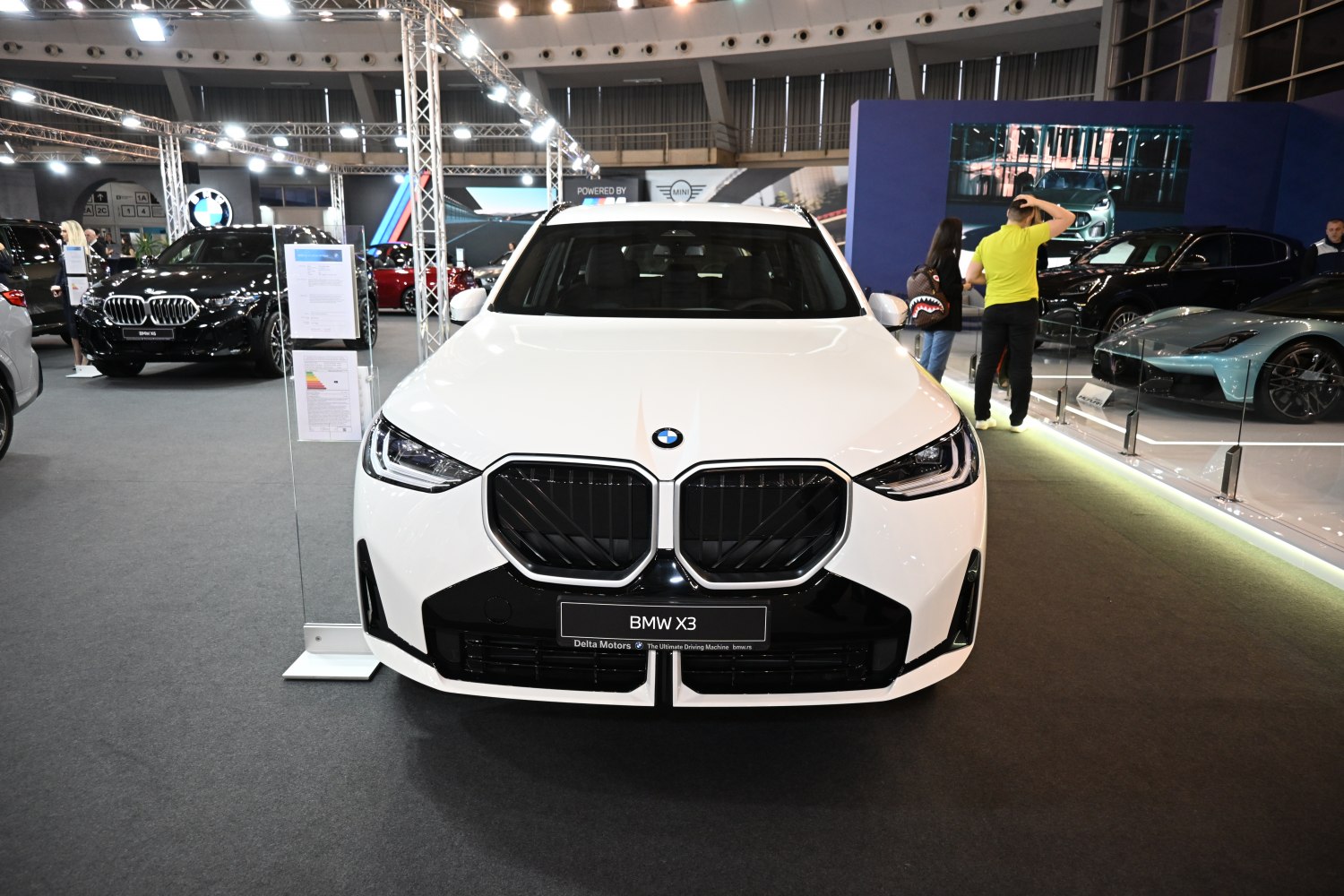Front view with large kidney grille and sleek headlights in white.