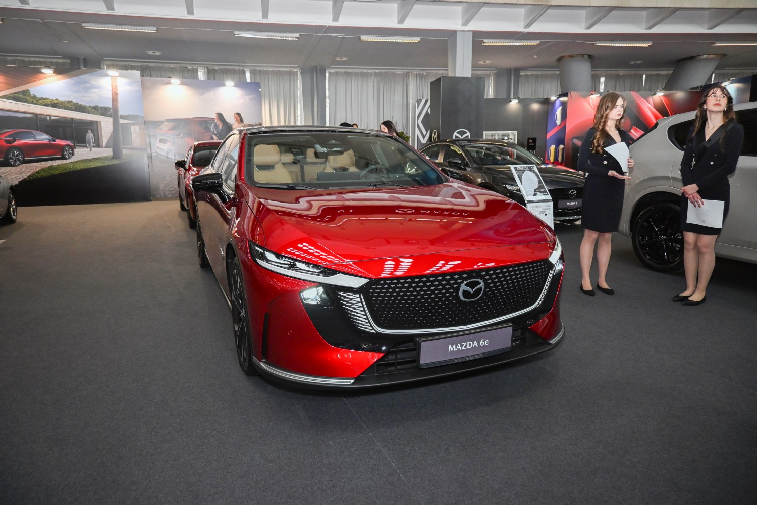 Front grille and sleek LED headlights of a red electric sedan