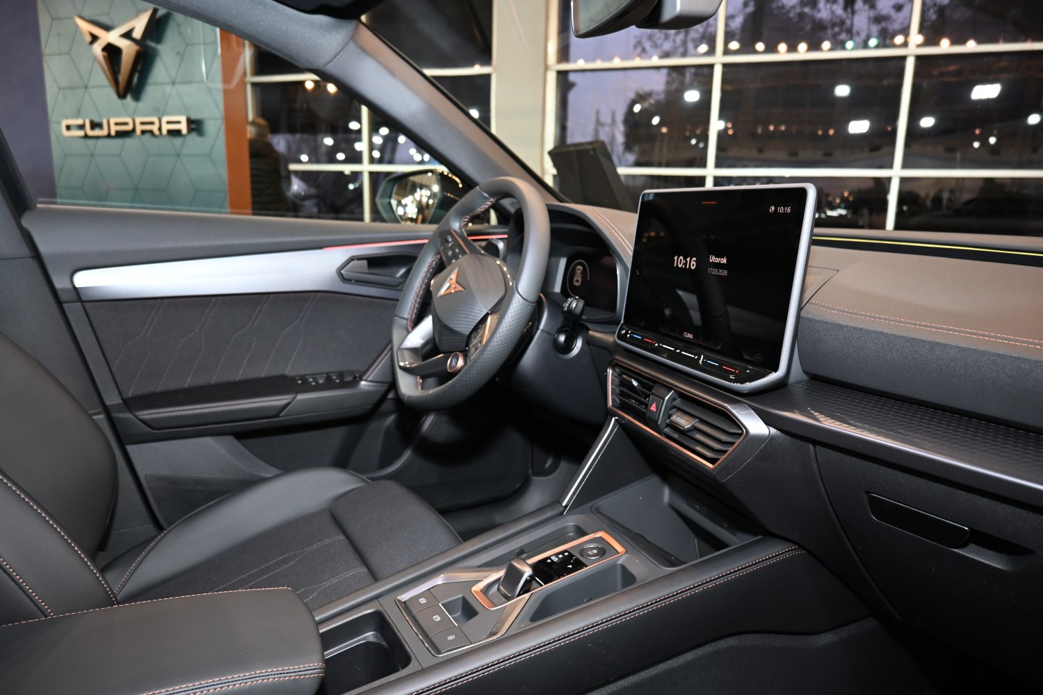 Modern car interior with touchscreen display and premium steering wheel.