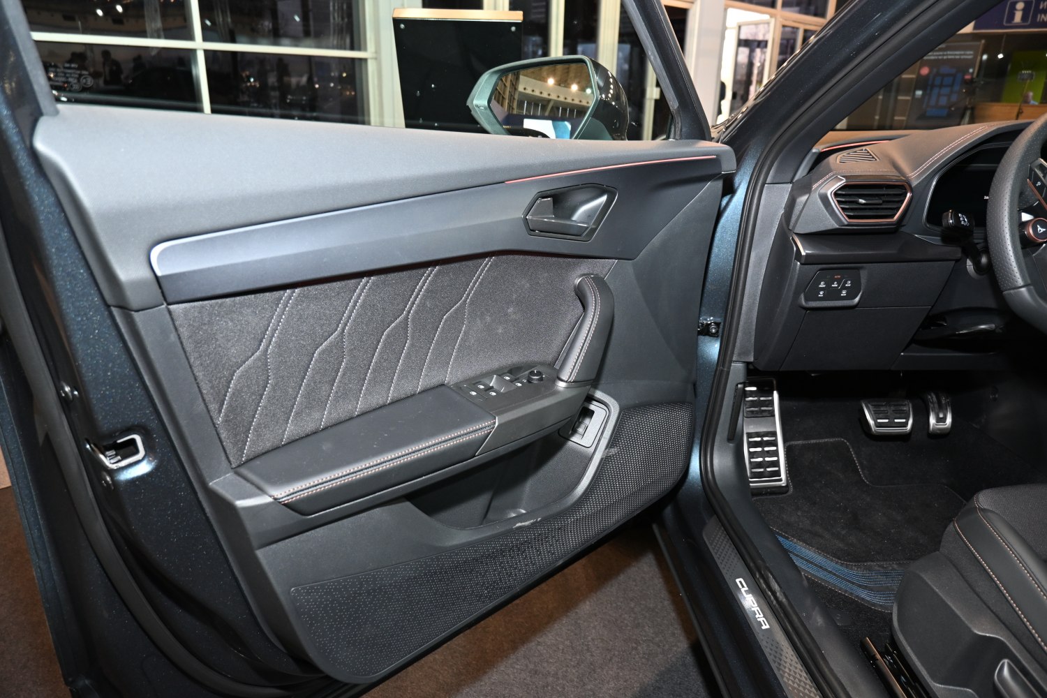 Interior door panel with stitched fabric and control buttons